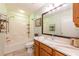 Bathroom with wood vanity, granite countertop, framed mirror, toilet and shower-tub combo at 7978 Se 174Th Belhaven Loop, The Villages, FL 32162