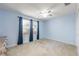 Bedroom with blue walls, carpet and window with curtains at 7978 Se 174Th Belhaven Loop, The Villages, FL 32162