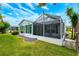 Exterior view of home showcasing the screened-in lanai and lush lawn at 7978 Se 174Th Belhaven Loop, The Villages, FL 32162