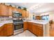 Well-lit kitchen with wooden cabinets, stainless steel appliances and a breakfast bar at 7978 Se 174Th Belhaven Loop, The Villages, FL 32162