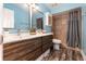 Bathroom features double sink vanity with wood cabinets, tile shower, and blue walls at 805 Leopard Trl, Winter Springs, FL 32708