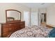 Bedroom showcasing a wooden dresser, doorway, and a comfortable bed with decorative pillows at 8276 Maritime Flag St # 110, Windermere, FL 34786