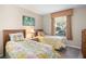 Cozy bedroom featuring two twin beds, tropical bedding, and a bright window at 8276 Maritime Flag St # 110, Windermere, FL 34786