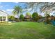 Large grassy backyard featuring palm trees and a playground at 9224 Bentley Park Cir, Orlando, FL 32819