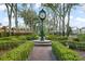 Eye-level perspective of the community clock tower surrounded by neatly trimmed greenery and mature trees at 9224 Bentley Park Cir, Orlando, FL 32819