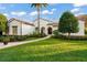 Stunning white home with a red tile roof, complemented by a lush green lawn and elegant landscaping at 9224 Bentley Park Cir, Orlando, FL 32819