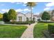 Charming home showcasing a well-manicured lawn, verdant landscaping, and a quaint stone pathway to the entrance at 9224 Bentley Park Cir, Orlando, FL 32819