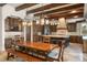 A large, rustic kitchen featuring a dining table, dark wood cabinets, beams, and decorative chandeliers at 9224 Bentley Park Cir, Orlando, FL 32819