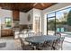 Outdoor dining area with a large metal table, travertine floors, an outdoor kitchen, and views of the pool at 9224 Bentley Park Cir, Orlando, FL 32819