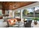 Inviting covered patio featuring travertine floors, wood ceilings, outdoor kitchen and views of the sparkling pool at 9224 Bentley Park Cir, Orlando, FL 32819