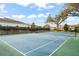 Blue and green tennis court provides a great recreational space and luxury houses visible in the background at 9224 Bentley Park Cir, Orlando, FL 32819