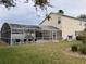 Spacious screened-in pool area extending from the back of a two-story home at 954 Lockbreeze Dr, Davenport, FL 33897