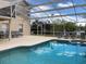 Enclosed pool area with patio furniture and view of the green yard beyond at 954 Lockbreeze Dr, Davenport, FL 33897