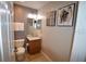 Cozy powder room features a single vanity, modern fixtures, toilet and artistic wall art at 954 Lockbreeze Dr, Davenport, FL 33897