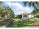 Lush backyard featuring well-maintained lawn, landscaping, and a view of the home with a screened-in lanai at 11866 Barletta Dr, Orlando, FL 32827