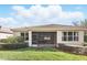 The backyard features lush grass, mature landscaping, and a screened-in lanai extending the living space outdoors at 11866 Barletta Dr, Orlando, FL 32827