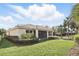 A spacious backyard showcasing lush greenery and a lanai, set against a backdrop of mature palm trees at 11866 Barletta Dr, Orlando, FL 32827