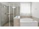 Modern bathroom featuring a glass shower, soaking tub, and tiled accents at 11866 Barletta Dr, Orlando, FL 32827
