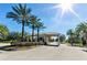 Community entrance featuring a covered gatehouse and tropical palm trees at 11866 Barletta Dr, Orlando, FL 32827