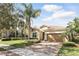 Inviting home exterior with lush landscaping, mature trees, and a brick driveway that enhances curb appeal at 11866 Barletta Dr, Orlando, FL 32827