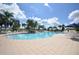 Community pool area surrounded by lounge chairs, palm trees, and blue umbrellas at 11866 Barletta Dr, Orlando, FL 32827