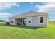 A spacious backyard showcasing the home's exterior, green lawn and covered patio at 1507 Fountain View St, Ormond Beach, FL 32174