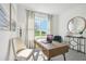 Cozy office with a wood desk, cream chair, decorative mirror, and large bright window at 1507 Fountain View St, Ormond Beach, FL 32174