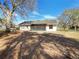 Exterior view of the backyard with trees and a white house with a screened porch at 15525 Seymour Ln, Groveland, FL 34736