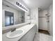 Bright bathroom featuring double sinks, large mirrors, and a walk-in shower at 15525 Seymour Ln, Groveland, FL 34736