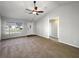 Open living room with carpet, neutral paint, and a ceiling fan at 15525 Seymour Ln, Groveland, FL 34736