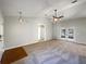 Spacious living room with carpeted floors, a ceiling fan, and French doors at 15525 Seymour Ln, Groveland, FL 34736