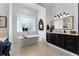 Serene bathroom featuring a modern standalone tub, glass block window, and dark wood vanity with stone countertops at 1613 Glenwick Dr, Windermere, FL 34786