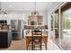 Cozy dining area featuring a rustic wooden table, modern lighting, and sliding glass doors to the outdoor pool at 1613 Glenwick Dr, Windermere, FL 34786