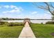 Scenic view of a wooden dock and gazebo on the lake, with a concrete path leading to it at 1613 Glenwick Dr, Windermere, FL 34786