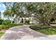 Stunning home exterior with mature trees, beautiful landscaping, and a winding brick driveway at 1613 Glenwick Dr, Windermere, FL 34786