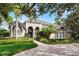 Elegant home featuring lush landscaping, a brick paved driveway, and a gated entrance under a blue sky at 1613 Glenwick Dr, Windermere, FL 34786