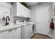 Functional laundry room with modern washer and dryer, sink, and ample storage at 1613 Glenwick Dr, Windermere, FL 34786