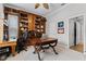 Home office showcasing custom built-in bookshelves, a classic desk, and neutral carpet flooring at 1613 Glenwick Dr, Windermere, FL 34786