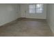Bright living room featuring neutral-toned tile flooring, a large window, and a white front door at 1616 Ferndell Rd, Orlando, FL 32808
