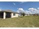 Well-maintained backyard featuring a screened patio, manicured lawn, and views of neighboring homes under a bright sky at 17667 Saw Palmetto, Clermont, FL 34714