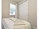 Cozy bedroom featuring a window with blinds, a closet with sliding doors, and a comfortable bed with patterned linens at 17667 Saw Palmetto, Clermont, FL 34714