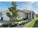 Well-maintained home exterior featuring manicured landscaping, a brick driveway, and a welcoming entrance at 17667 Saw Palmetto, Clermont, FL 34714