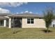 Rear exterior showcasing a screened patio, a window, and the home's siding, complemented by a well-kept lawn at 17667 Saw Palmetto, Clermont, FL 34714