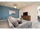 Cozy living room boasts a large gray sectional, entertainment center, and stylish blue accent wall at 17667 Saw Palmetto, Clermont, FL 34714