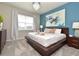 Bright main bedroom features a platform bed, a blue accent wall, and a view from the window at 17667 Saw Palmetto, Clermont, FL 34714