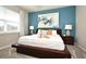 Serene main bedroom featuring a platform bed, blue accent wall, and matching nightstands with lamps at 17667 Saw Palmetto, Clermont, FL 34714