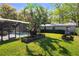 A lush backyard includes a screened pool enclosure, a wooden garden bed, and ample lawn space at 1832 Magnolia Ave, Winter Park, FL 32789