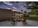 This backyard includes a fire pit seating area, a screened pool enclosure, and a lush lawn under an evening sky at 1832 Magnolia Ave, Winter Park, FL 32789