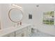 Stylish bathroom features decorative tile, a round mirror, updated vanity, and a window at 1832 Magnolia Ave, Winter Park, FL 32789