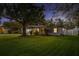 The well-maintained front yard of this home features a lush lawn and mature trees under an evening sky at 1832 Magnolia Ave, Winter Park, FL 32789